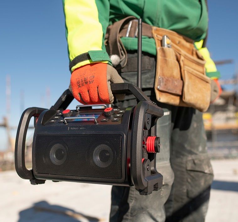 Een radio voor de bouwplaats in de hand van een vakman